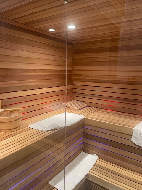 7x9 Cedar Sauna Materials Package 3 7x9 SMP Glass Front Wall with Chromatherapy lights behind bench facing
